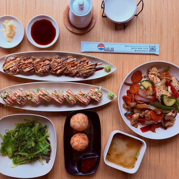 An overhead shot of a Kaja restaurant meal with sushi, stir-fry, seaweed salad, and miso soup.