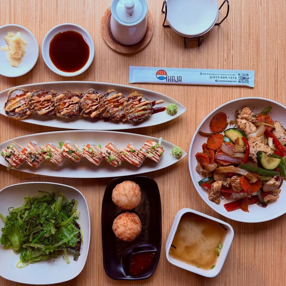 An overhead shot of a Kaja restaurant meal with sushi, stir-fry, seaweed salad, and miso soup.